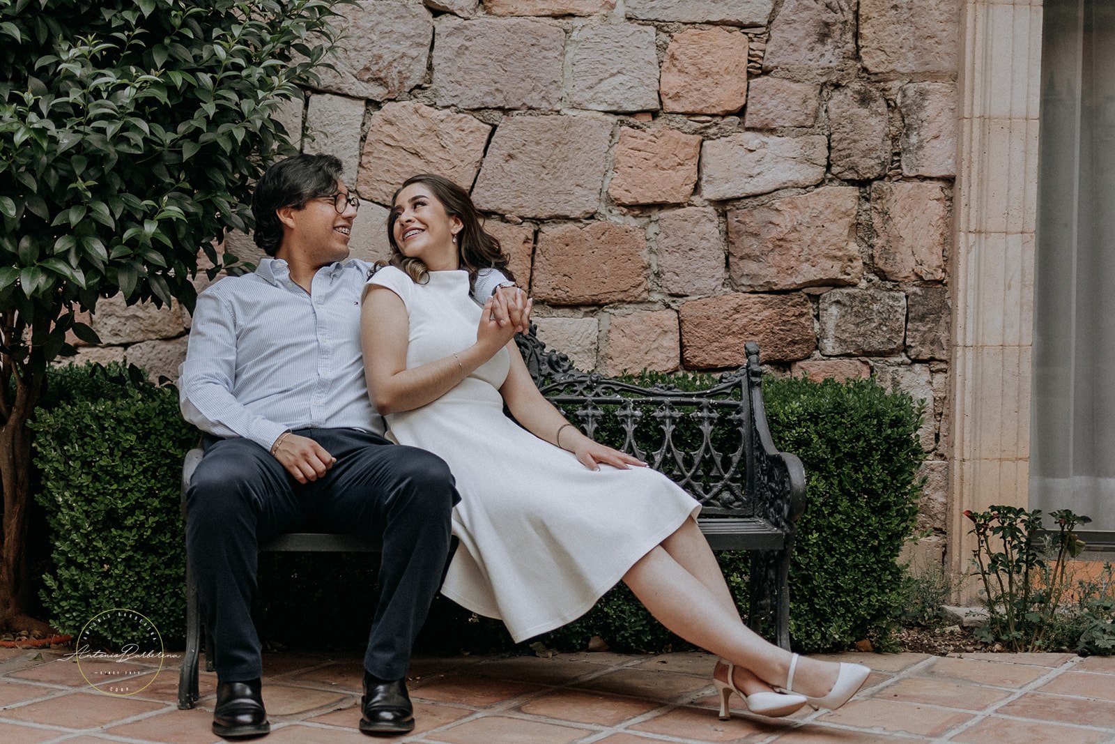 Pareja riendo juntos sentados en banco ornamentado