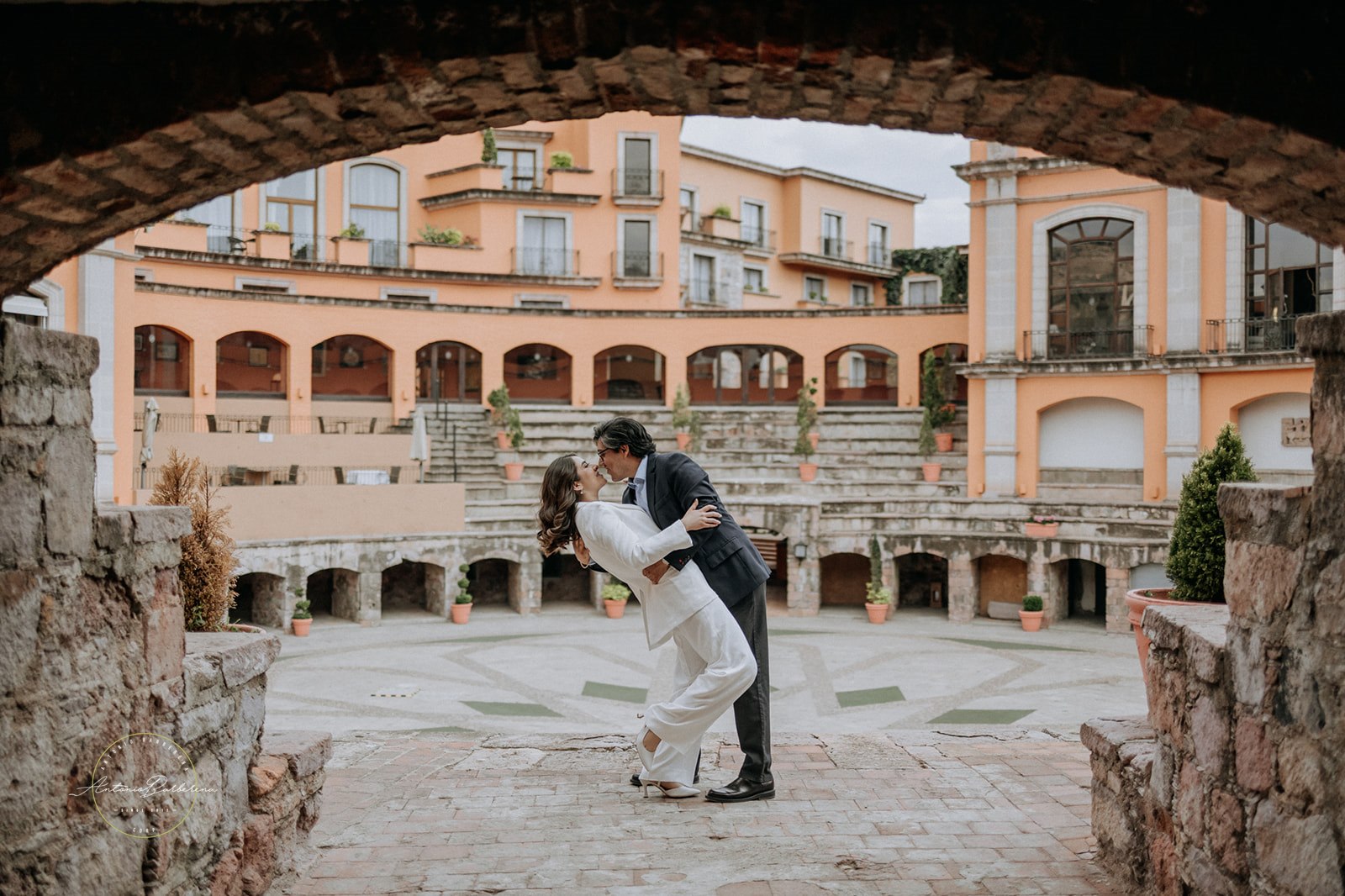 Pareja abrazándose en patio colonial mexicano